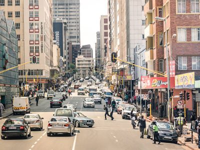 Johannesburg, South Africa - November 13, 2014: rush hour and traffic jam with everyday life people on Von Wiellig Street at the crossroad with Comminsioner St in the crowded and modern multiracial metropolis of South Africa.