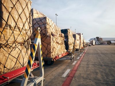 Loading of cargo containers to airplane at airport.